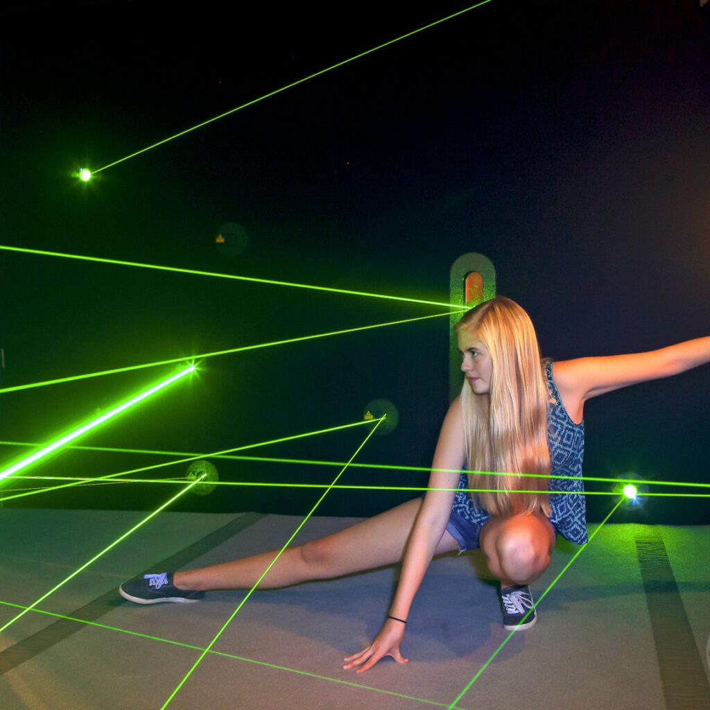 Girl crouched in laser maze.