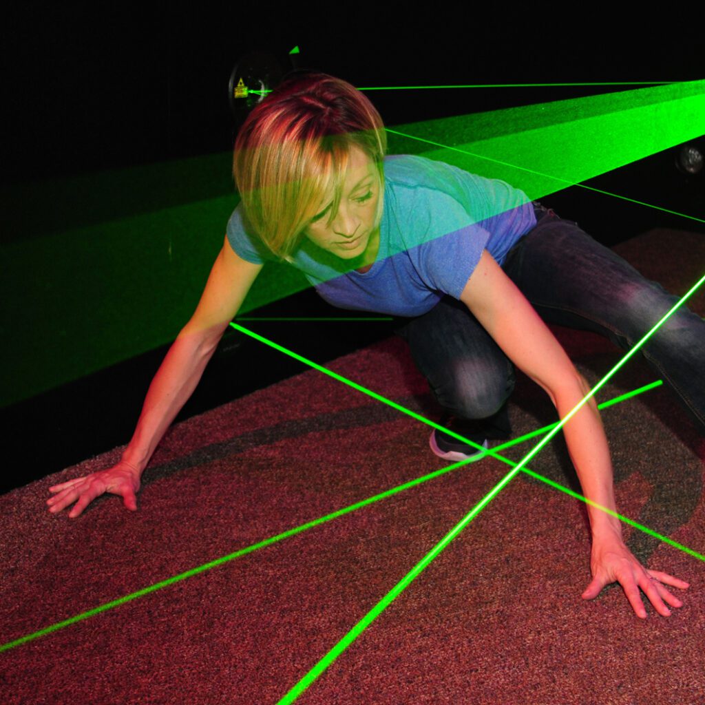 Woman in blue shirt in laser maze.